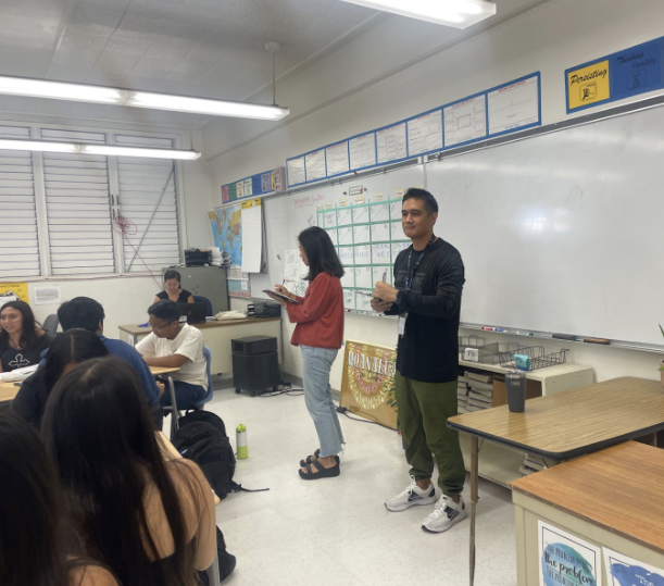 Ms. Whang and Mr. Nishimura observe and take notes in a 9th-grade English class.